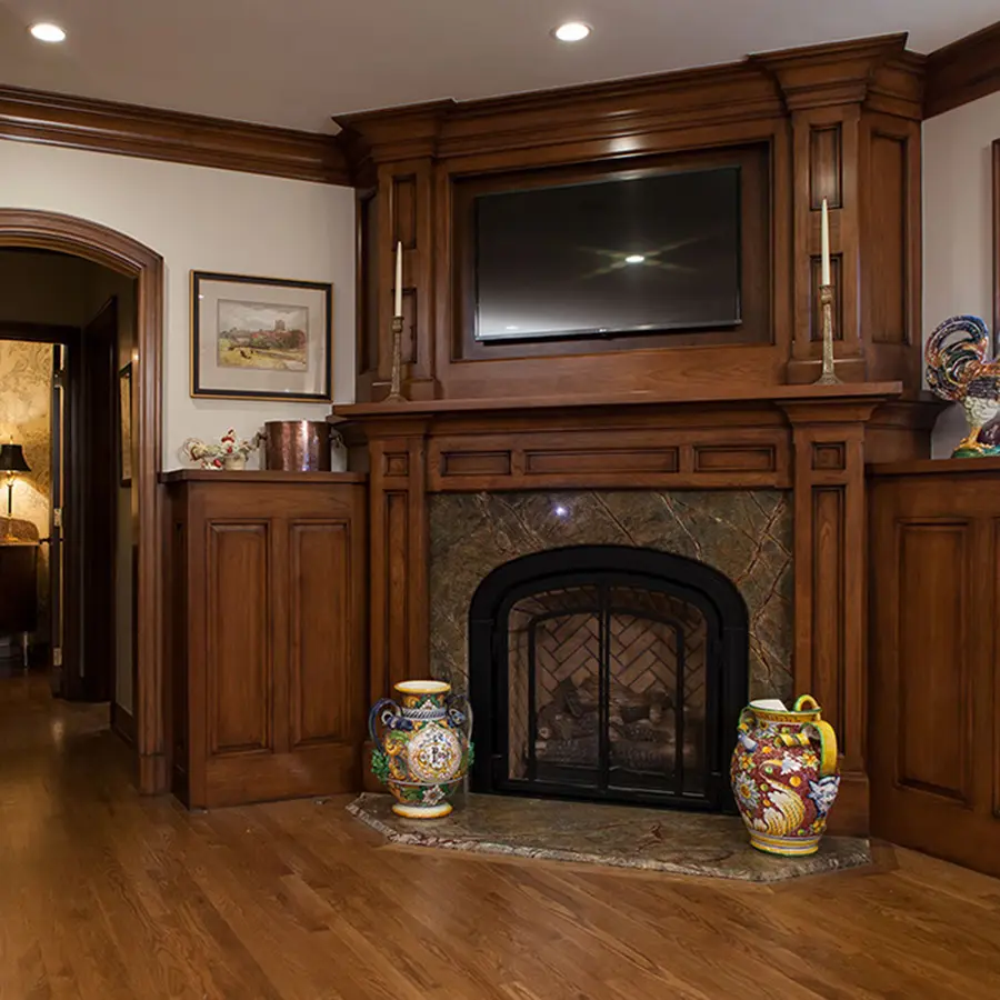 Stained wood fireplace surround with built-in TV niche and flanking cabinets