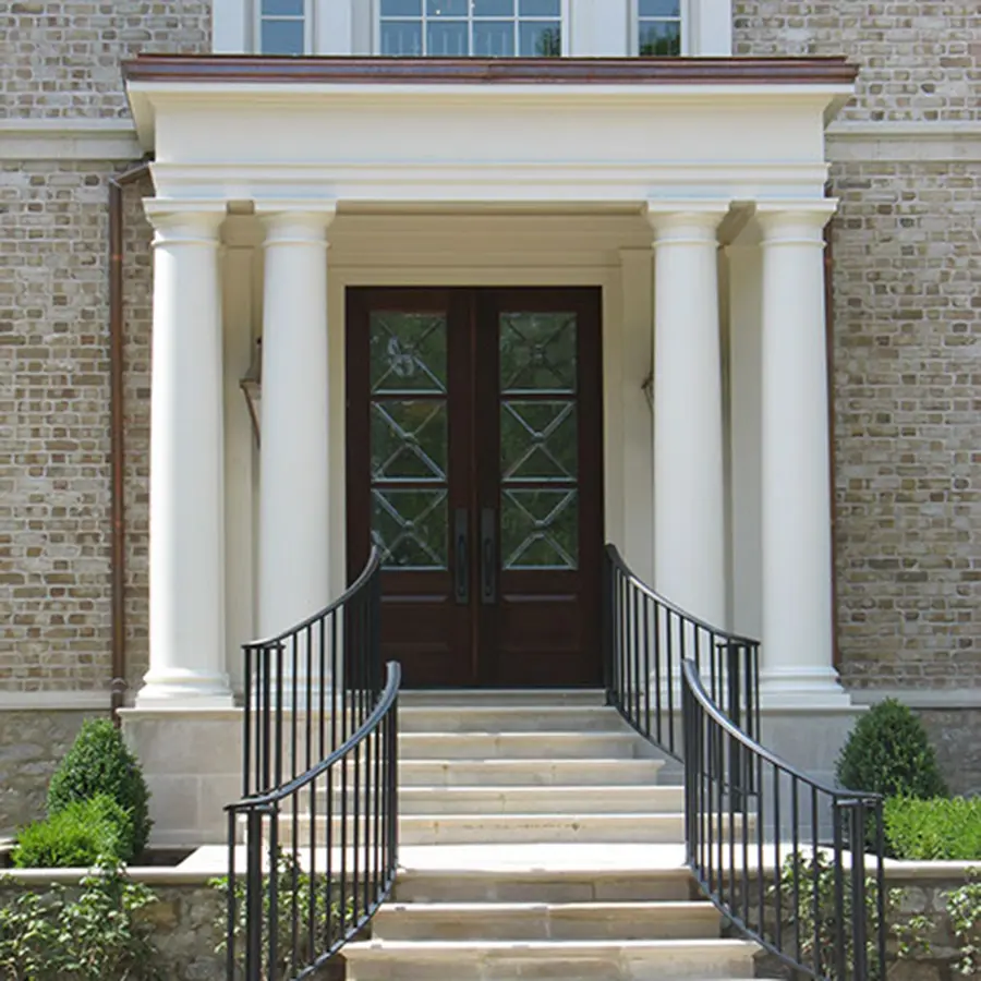 Brick home entry with columned portico, double wood doors and stone steps
