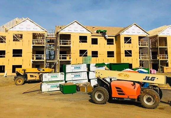 Apartment buildings under construction with Weyerhaeuser Edge materials and a JLG telehandler