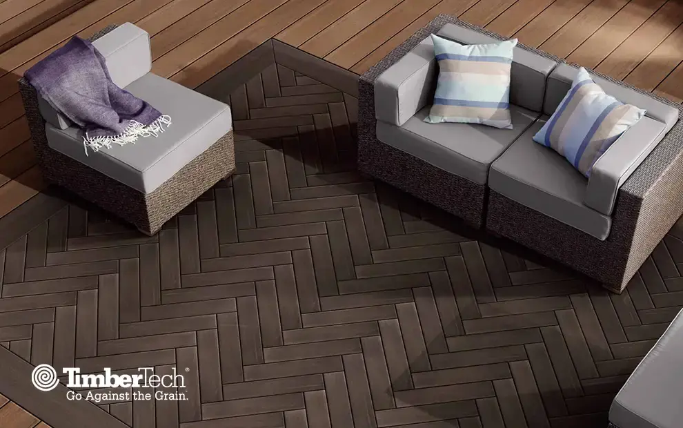 Composite deck with a herringbone inlay pattern and wicker lounge chairs