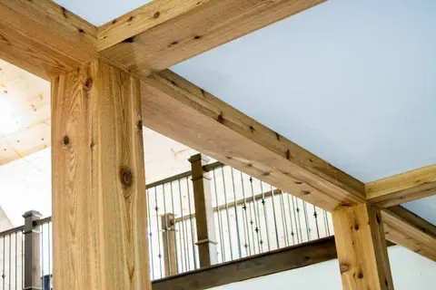 Rough-sawn timber posts and beams with a metal baluster railing