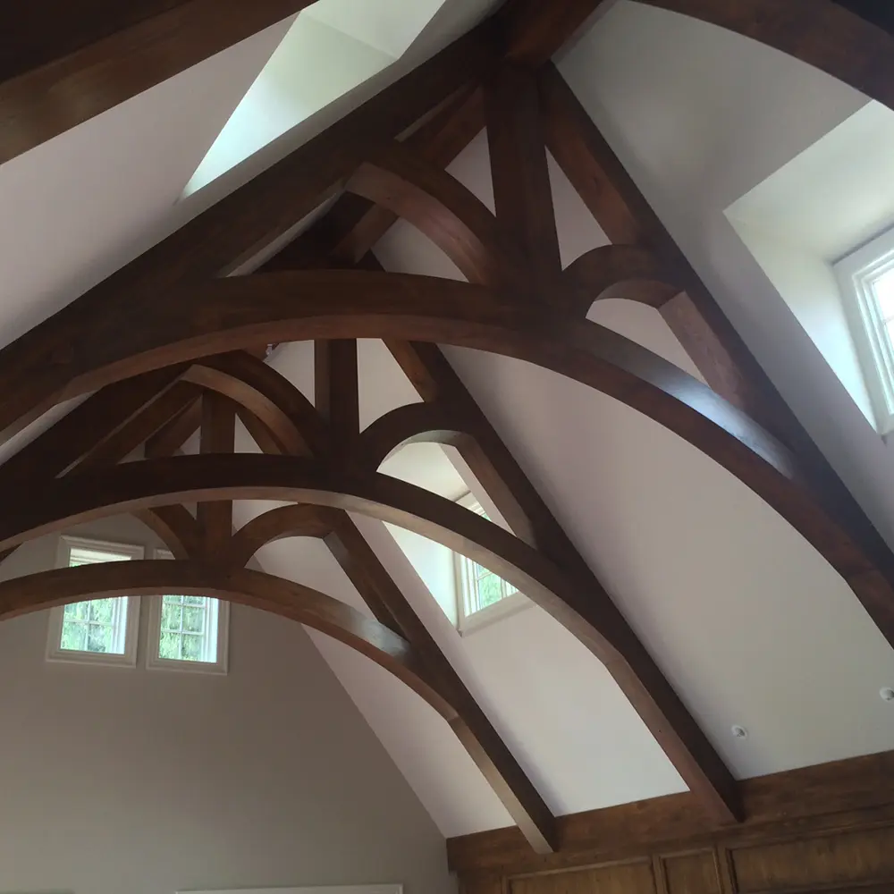 Vaulted ceiling with dark stained curved timber trusses and arched braces