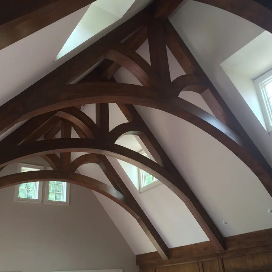 Vaulted ceiling with dark stained curved timber trusses and arched braces